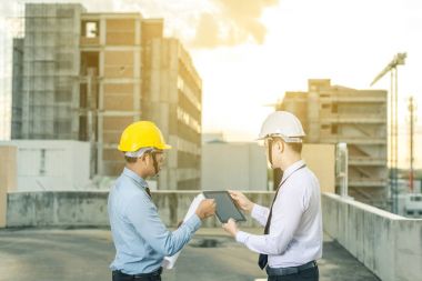 Gülümseyen genç mimar veya Oluşturucusu'nda kask ile mühendislik 