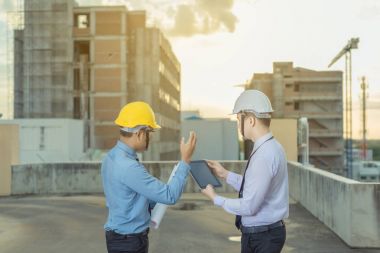 Gülümseyen genç mimar veya Oluşturucusu'nda kask ile mühendislik 