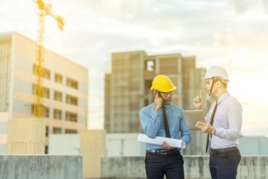 Gülümseyen genç mimar veya Oluşturucusu'nda kask ile mühendislik 