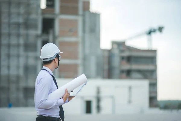 Sonriente joven arquitecto o constructor de ingeniería en casco duro con — Foto de Stock