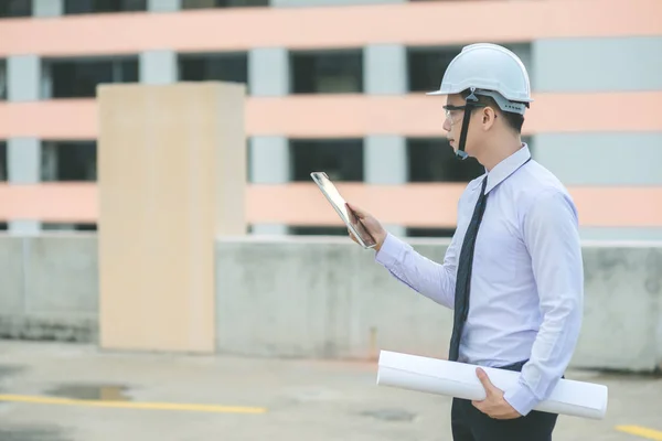 Jeune architecte souriant ou constructeur d'ingénierie en casque dur avec — Photo