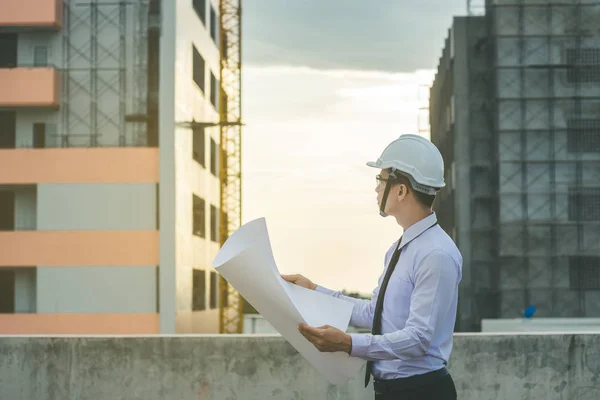 Sonriente joven arquitecto o constructor de ingeniería en casco duro con — Foto de Stock