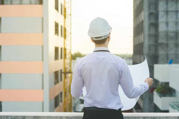 Sonriente joven arquitecto o constructor de ingeniería en casco duro con — Foto de Stock