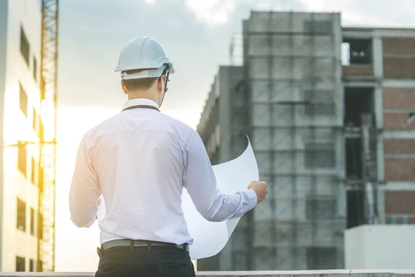 Gülümseyen genç mimar veya Oluşturucusu'nda kask ile mühendislik 