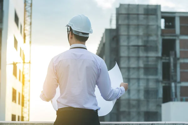 Gülümseyen genç mimar veya Oluşturucusu'nda kask ile mühendislik 