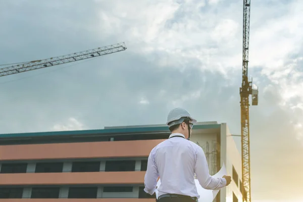 Sonriente joven arquitecto o constructor de ingeniería en casco duro con — Foto de Stock