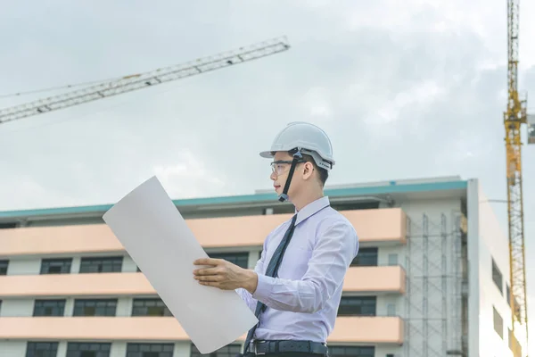 Sonriente joven arquitecto o constructor de ingeniería en casco duro con — Foto de Stock