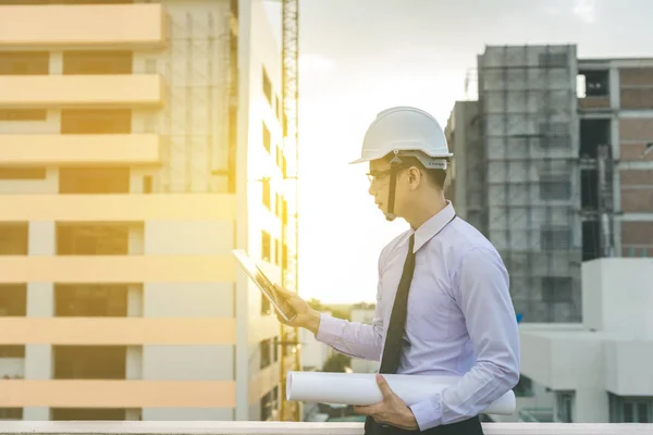 Sonriente joven arquitecto o constructor de ingeniería en casco duro con — Foto de Stock