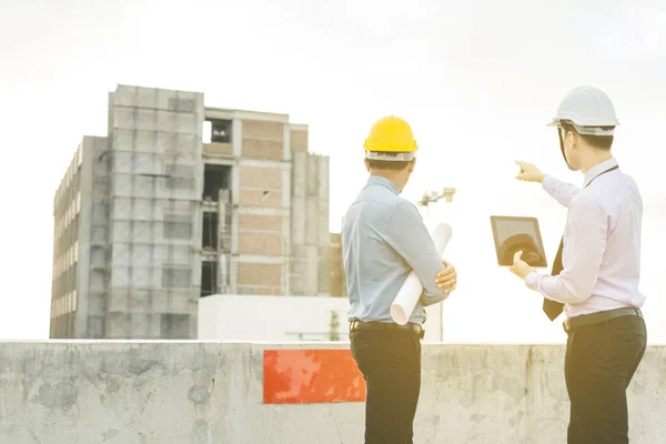 Sonriente joven arquitecto o constructor de ingeniería en casco duro con — Foto de Stock