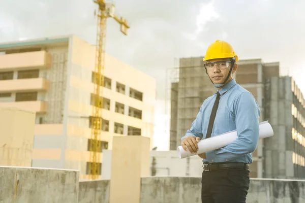 Jeune architecte souriant ou constructeur d'ingénierie en casque dur avec — Photo