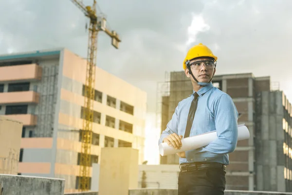 Sonriente joven arquitecto o constructor de ingeniería en casco duro con — Foto de Stock