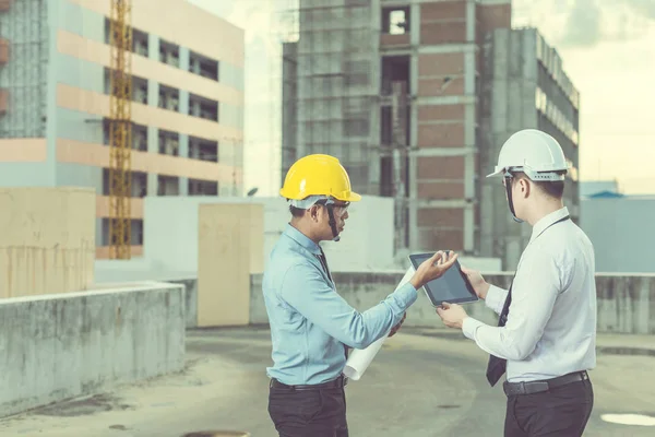 Sonriente joven arquitecto o constructor de ingeniería en casco duro con — Foto de Stock