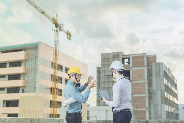 Sonriente joven arquitecto o constructor de ingeniería en casco duro con — Foto de Stock