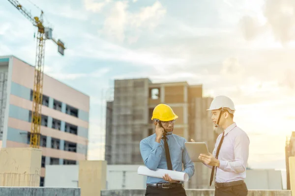 Sonriente joven arquitecto o constructor de ingeniería en casco duro con — Foto de Stock