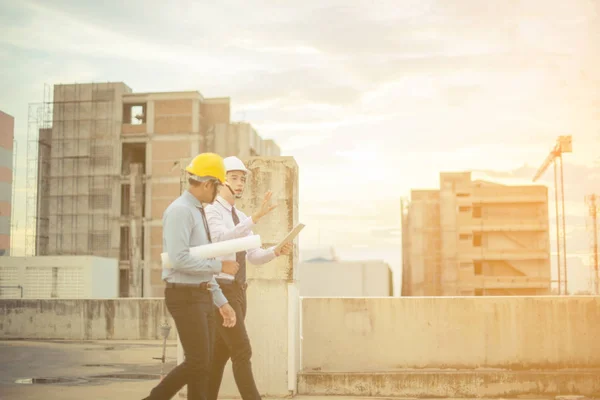 Sonriente joven arquitecto o constructor de ingeniería en casco duro con — Foto de Stock