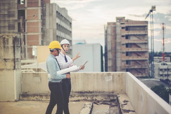 Sonriente joven arquitecto o constructor de ingeniería en casco duro con — Foto de Stock