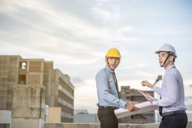 Gülümseyen genç mimar veya Oluşturucusu'nda kask ile mühendislik 