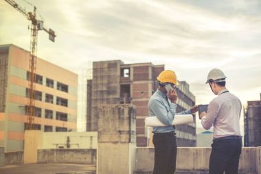 Gülümseyen genç mimar veya Oluşturucusu'nda kask ile mühendislik 