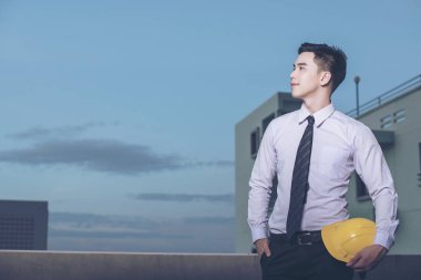 Gülümseyen genç mimar veya Oluşturucusu'nda kask ile mühendislik 