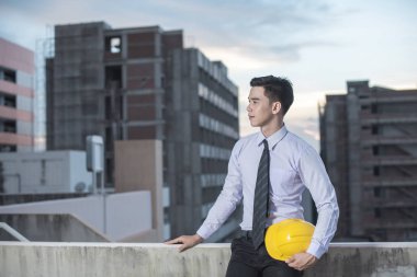 Gülümseyen genç mimar veya Oluşturucusu'nda kask ile mühendislik 