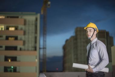 Gülümseyen genç mimar veya Oluşturucusu'nda kask ile mühendislik 