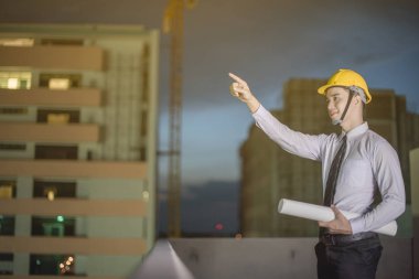 Gülümseyen genç mimar veya Oluşturucusu'nda kask ile mühendislik 