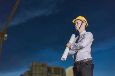 Gülümseyen genç mimar veya Oluşturucusu'nda kask ile mühendislik 