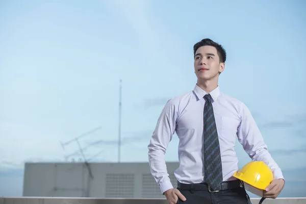 Gülümseyen genç mimar veya Oluşturucusu'nda kask ile mühendislik 