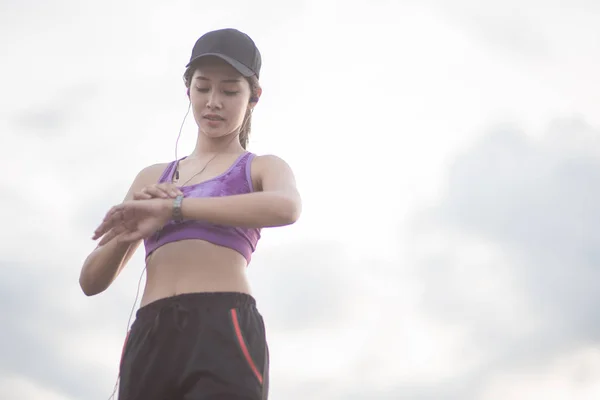 Glimlachen van Asia vrouw atleet zittend op een oefening mat en str — Stockfoto