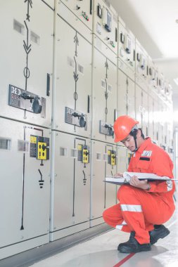 Mühendisler elektrik sistemi kontrol ediyor. Seçici odak. Mühendis ve yöneticiler planları görüşüyorlar