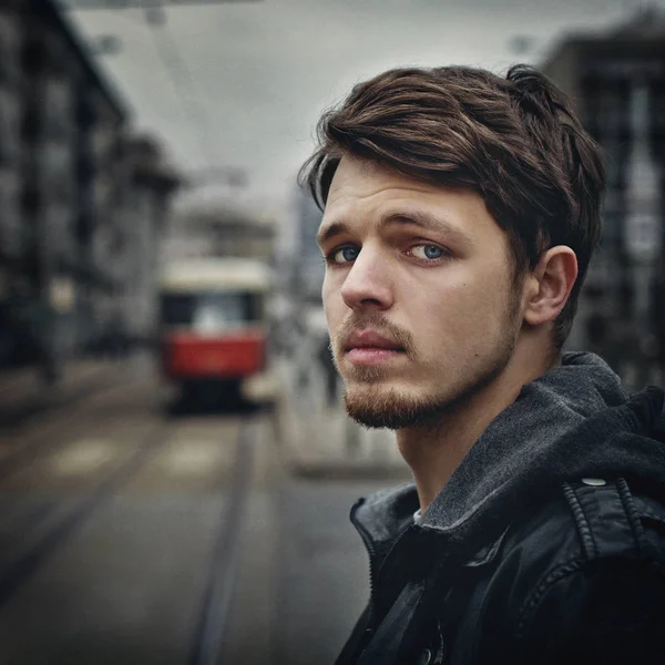 Attractive young man outdoors.Closeup portrait of a young handsome man .A sad young man on a city street.