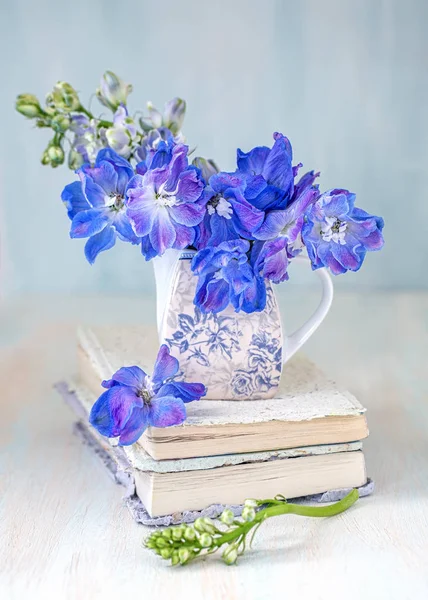 白色的花 在桌子上有一朵蓝色的花的特写 蓝色背景上有一束美丽的花 — 图库照片