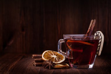 Ahşap masada sıcak şarap ve baharatlar.