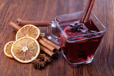 Ahşap masada sıcak şarap ve baharatlar.