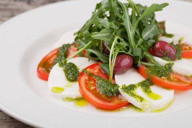 Beyaz bir tabak üzerinde taze Caprese salatası