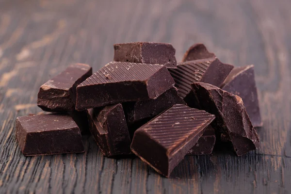 Potongan coklat hitam alami di atas meja kayu — Stok Foto