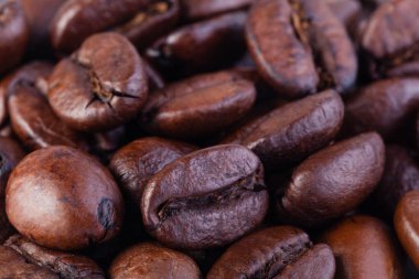 Kızarmış kahve çekirdekleri beyaz arka planda izole edilmiş.