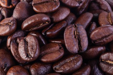 Kızarmış kahve çekirdekleri beyaz arka planda izole edilmiş.