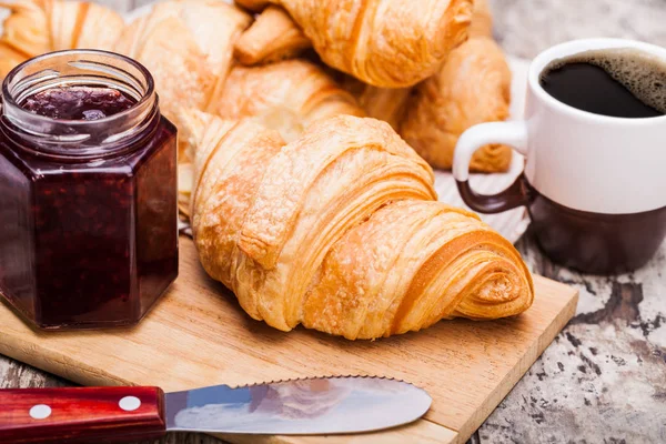 Croissant freschi su sfondo rustico in legno — Foto Stock