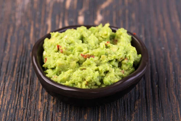 Bir tahta üzerinde bir kase guacamole — Stok fotoğraf