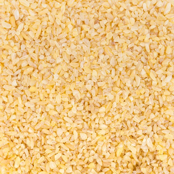 Grani di Bulgur, frumento crepato come sfondo — Foto Stock