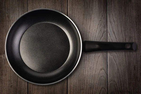 Empty frying pan on wooden background — Stock Photo, Image