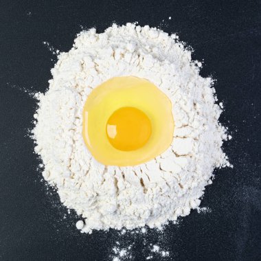 Siyah arka planda yuvarlak iğne ve beyaz un. Üst görünüm.