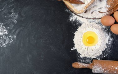 Hamur hazırlığı. Koyu arkaplanda un olan merdane. Metin için boş alan.