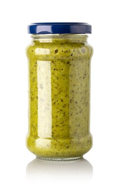 Cam kavanozdaki fesleğen sosu beyaz arka planda izole edilmiş.