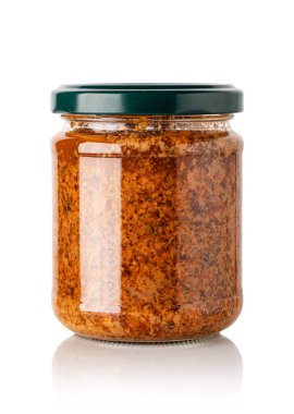 Kırmızı fesleğen sosu cam kavanozda, beyaz arka planda izole edilmiş.