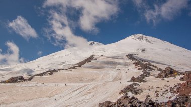 Kafkasya, Rusya 'daki Elbrus Dağı manzarası. Batı ve doğu zirvesi (5642). Bir dağcı iniyor, donmuş yolda yürüyor..