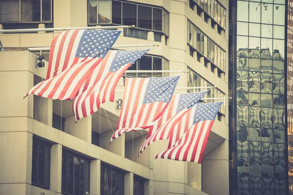 Banderas americanas en los asta de la bandera en el edificio Imagen de stock