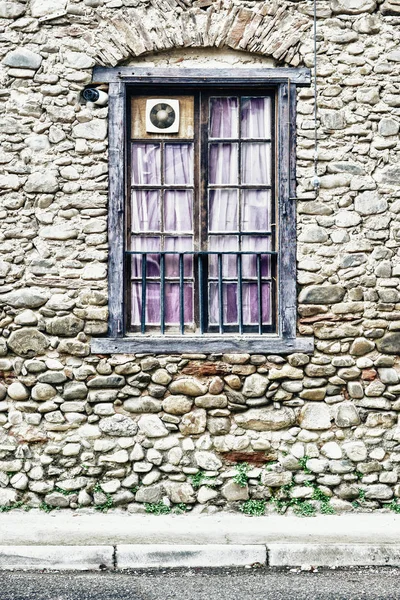 Каменная стена с деревянным окном — стоковое фото