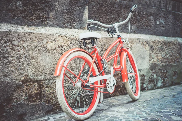 Vélo rouge stationné près du mur de pierre — Photo